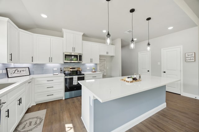 kitchen featuring backsplash, white cabinetry, appliances with stainless steel finishes, and dark wood finished floors