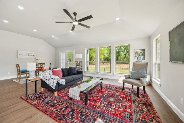 living area with baseboards, a ceiling fan, wood finished floors, and lofted ceiling