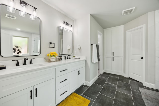 bathroom featuring visible vents, a sink, and double vanity
