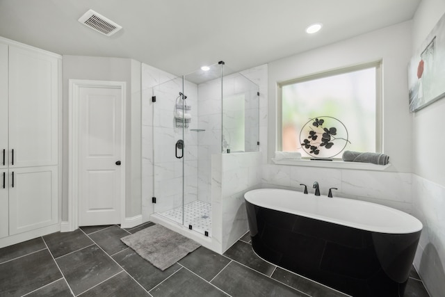 full bath featuring a marble finish shower, a soaking tub, and visible vents