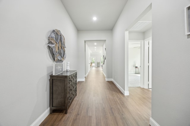 hallway with recessed lighting, baseboards, and wood finished floors