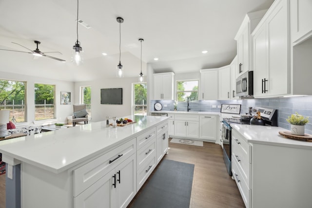 kitchen with decorative backsplash, a ceiling fan, light countertops, white cabinets, and stainless steel appliances