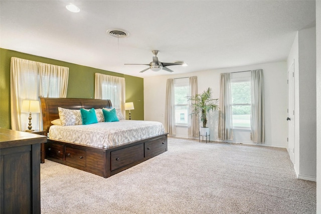 bedroom with light colored carpet, baseboards, ceiling fan, and visible vents
