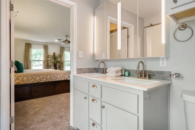 bathroom featuring a sink, toilet, double vanity, and connected bathroom