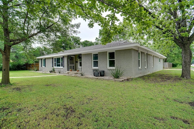 ranch-style home featuring fence, a front yard, and brick siding