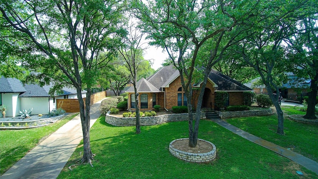 view of front of house with brick siding, fence, and a front yard