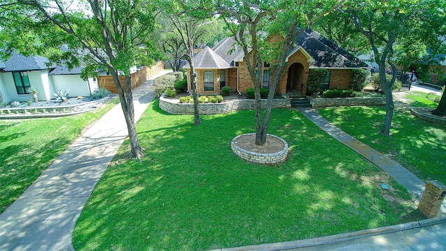 tudor home with brick siding and a front yard