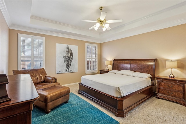 carpeted bedroom with crown molding, a ceiling fan, and a tray ceiling