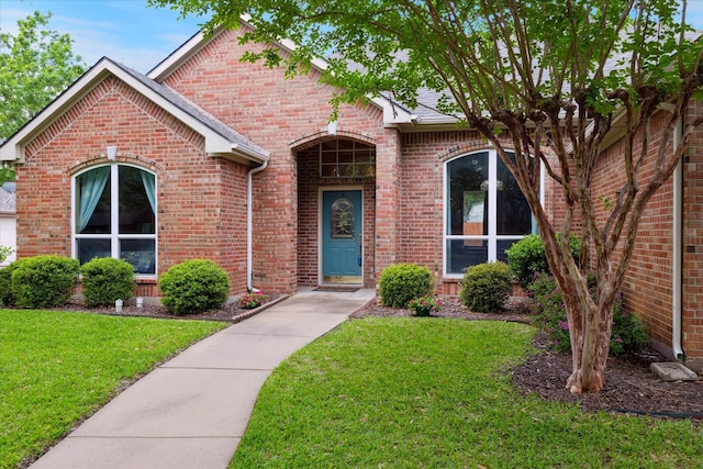 ranch-style home with brick siding and a front yard