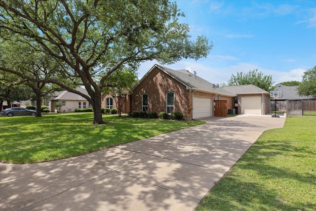 view of front of house with fence, a front lawn, brick siding, a garage, and driveway