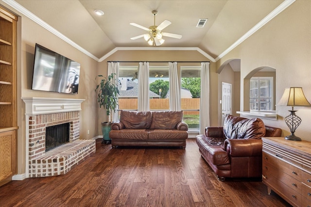 living area with ceiling fan, visible vents, a fireplace, vaulted ceiling, and dark wood-style floors
