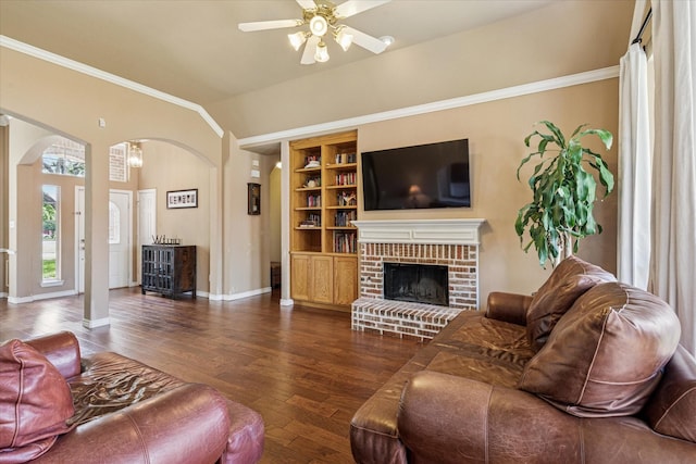 living room with crown molding, arched walkways, ceiling fan, and wood finished floors