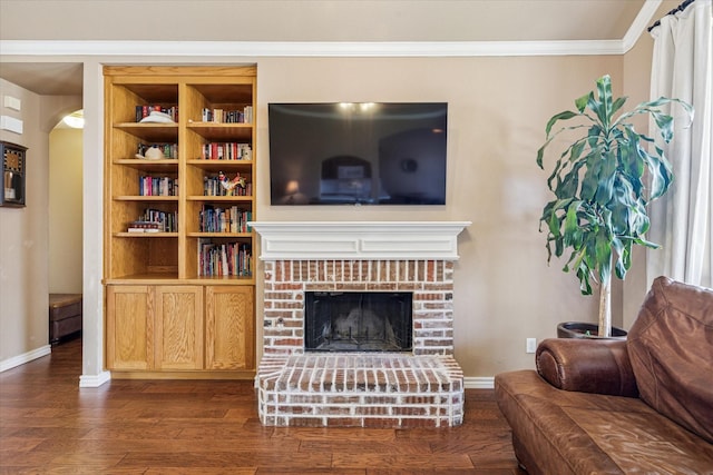 living room featuring crown molding, baseboards, a fireplace, and dark wood-style flooring