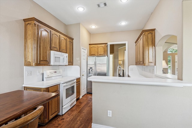 kitchen featuring light countertops, dark wood-style flooring, white appliances, and visible vents