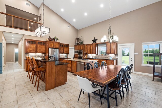 1009 Western Dr, Woodway, TX 76712 - dining room with high vaulted ceiling, a chandelier, baseboards, and visible vents