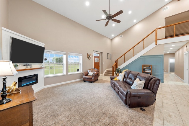 1009 Western Dr, Woodway, TX 76712 - living room featuring visible vents, stairs, a glass covered fireplace, ceiling fan, and high vaulted ceiling