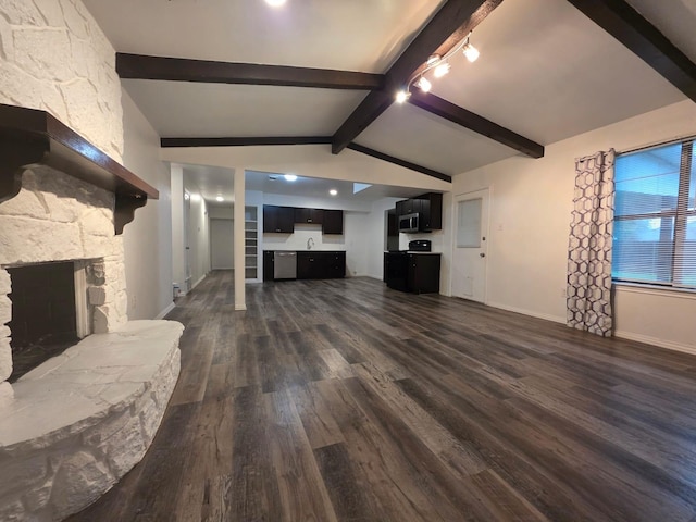 unfurnished living room featuring vaulted ceiling with beams, dark wood finished floors, baseboards, and a stone fireplace