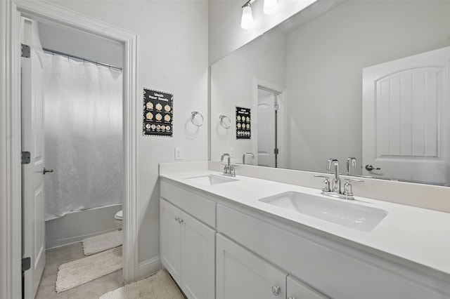 full bathroom featuring a sink, toilet, double vanity, and shower / tub combo