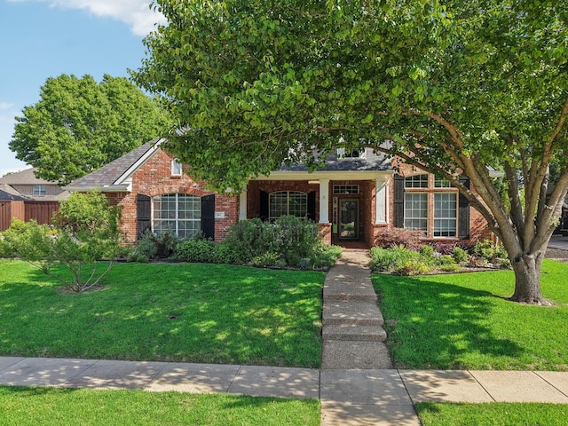 view of front facade featuring brick siding and a front yard