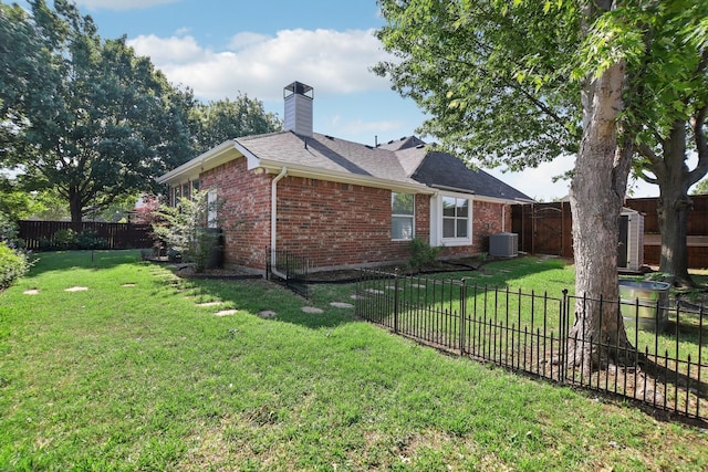 view of home's exterior with brick siding, a fenced backyard, and a yard