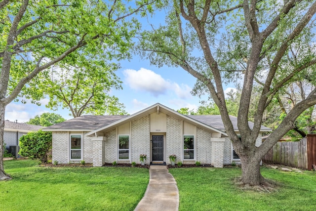 mid-century inspired home with fence, a front lawn, and brick siding