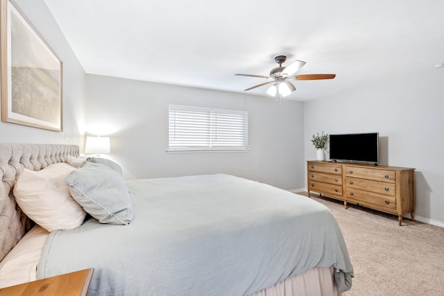 bedroom featuring baseboards, ceiling fan, and light carpet