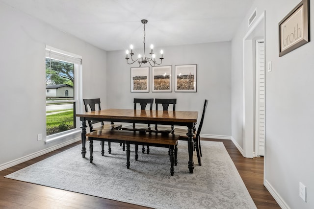 dining space featuring baseboards, a notable chandelier, visible vents, and dark wood-type flooring