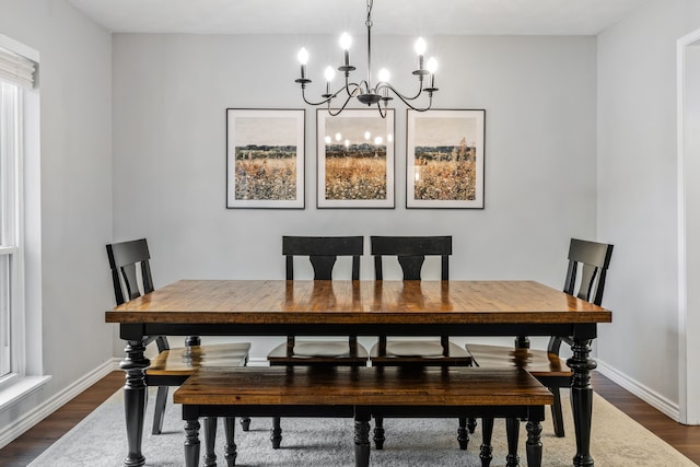dining room featuring baseboards, dark wood-type flooring, and a notable chandelier