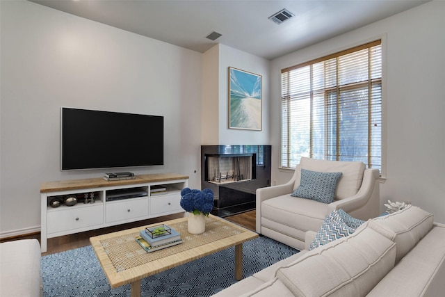 living area with visible vents, wood finished floors, and a wealth of natural light