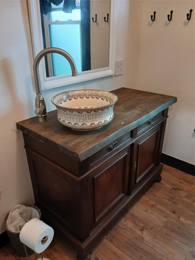 interior details with vanity and wood finished floors
