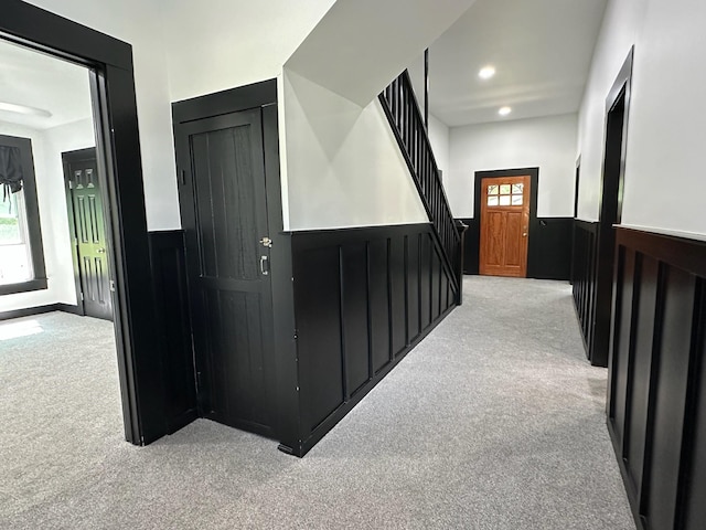corridor with carpet floors, recessed lighting, and wainscoting