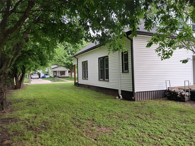 view of side of home with a yard