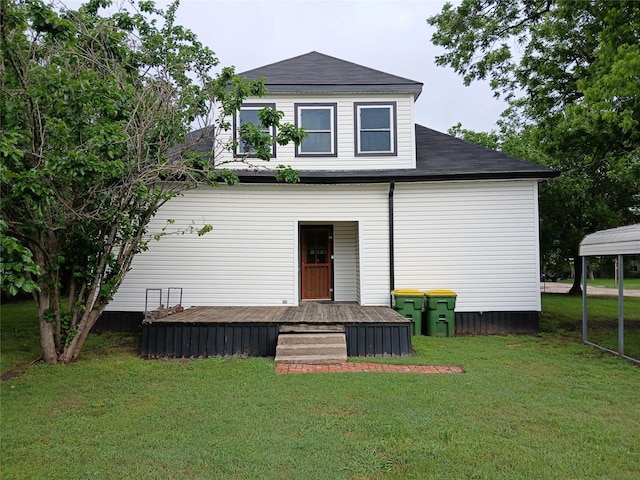 back of property with a lawn, roof with shingles, and a wooden deck