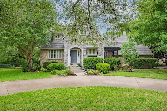 view of property hidden behind natural elements featuring a pergola, stone siding, brick siding, and a front yard