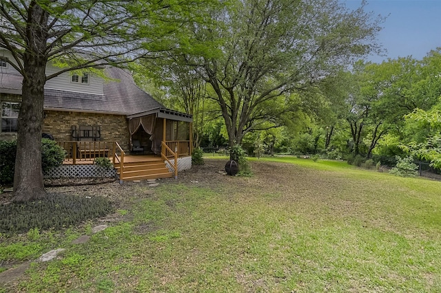 view of yard featuring fence, a wooden deck, and a sunroom