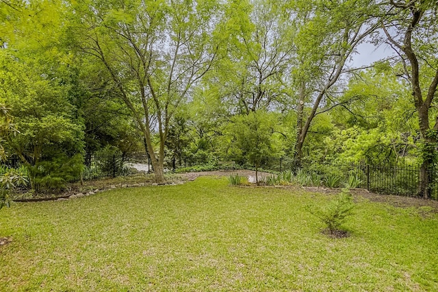 view of yard featuring fence and a wooded view