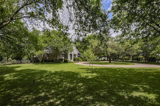 view of home's community featuring a lawn and fence