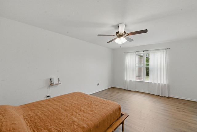 bedroom with baseboards, a ceiling fan, and wood finished floors