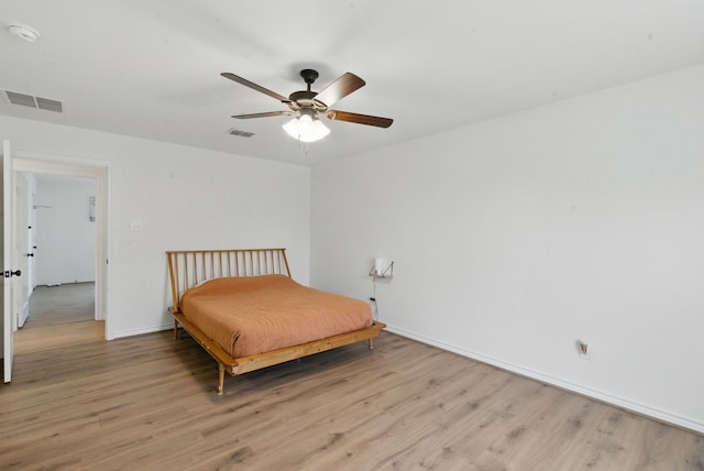 bedroom with baseboards, light wood-style flooring, and visible vents