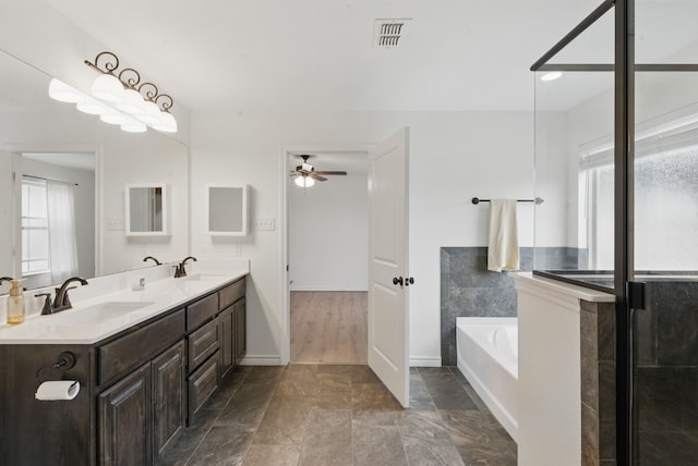 full bathroom with a sink, double vanity, a ceiling fan, visible vents, and a bath