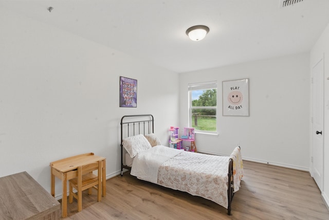 bedroom featuring baseboards and wood finished floors