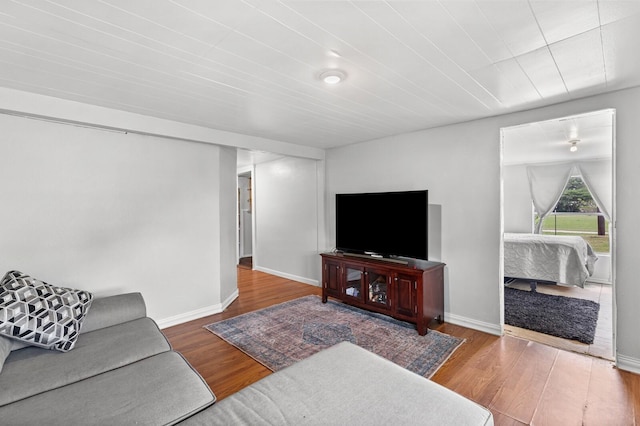 living area with baseboards and wood finished floors