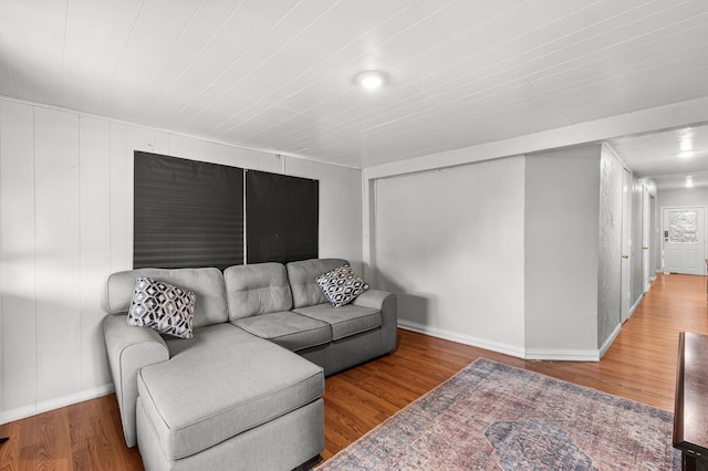 living area with baseboards and wood finished floors