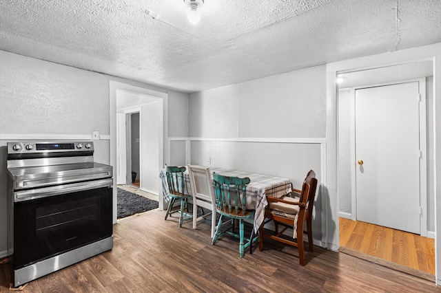 dining space with a textured ceiling and wood finished floors