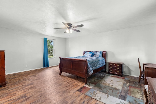 bedroom featuring a ceiling fan, baseboards, and wood finished floors