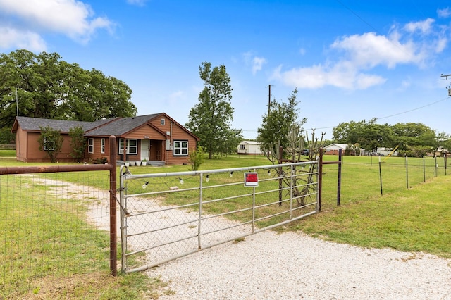 view of gate with fence private yard and a lawn