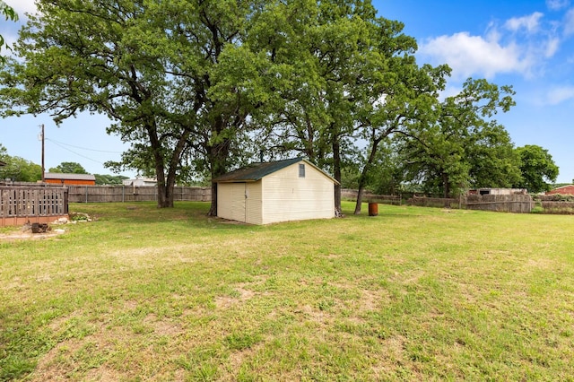 view of yard with an outdoor structure, fence, and a shed