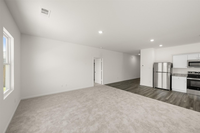 4936 Bass Dr, Fort Worth, TX 76179 - unfurnished living room with dark carpet, healthy amount of natural light, recessed lighting, and baseboards