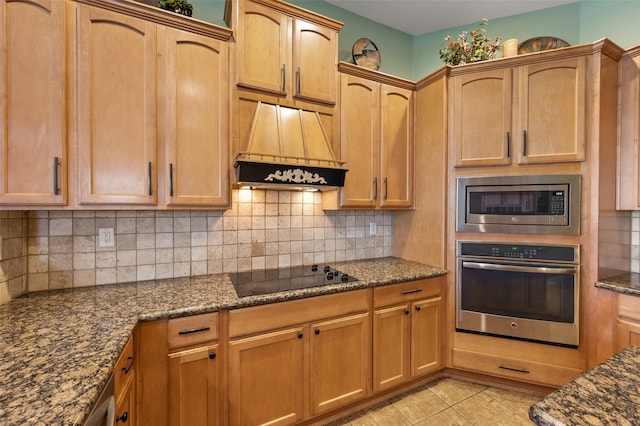 kitchen featuring appliances with stainless steel finishes, custom range hood, decorative backsplash, dark stone counters, and light tile patterned flooring