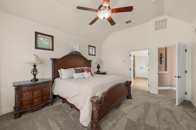 carpeted bedroom with vaulted ceiling, ceiling fan, baseboards, and ensuite bath